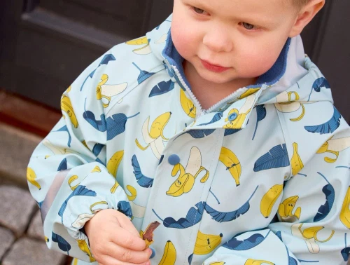 Dreng i regnjakke med bananprint fra CeLaVi 310454 7660 blue heaven